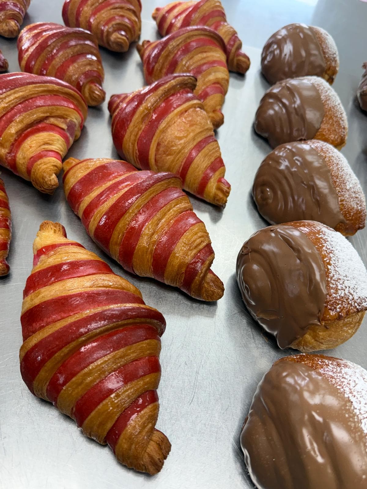 Two-tone croissants beside chocolate-dipped buns