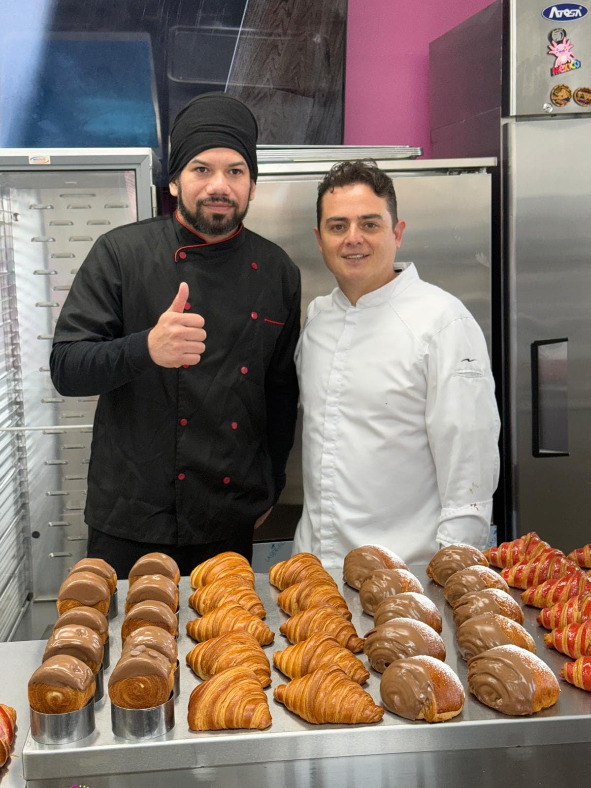 The Charlotte team in the bakery, behind a counter of freshly made croissants and pastries